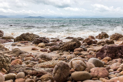 Stones at beach against sky