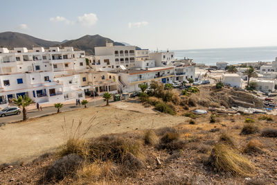 Buildings by sea against sky in city