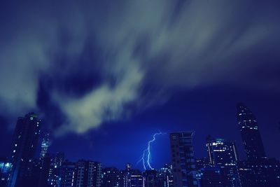 Illuminated cityscape against sky at night