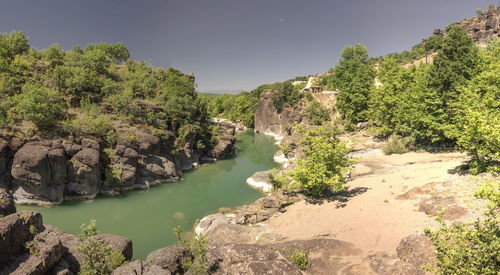 Scenic view of trees and rocks against sky