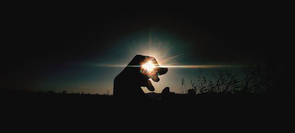 Silhouette man standing against sky during sunset