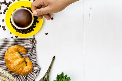 Directly above shot of hand holding coffee cup