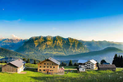 Houses in bezau with mountain against blue sky