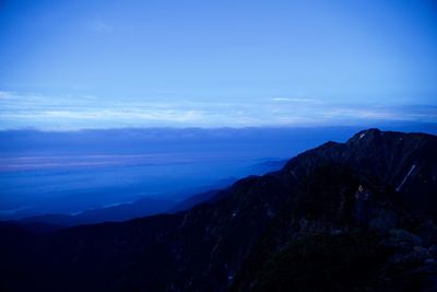 Scenic view of mountains against blue sky