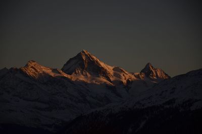 Snowcapped mountains against sky at night