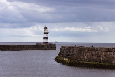 Iconic striped seaham lighthouse on pier with sea walls