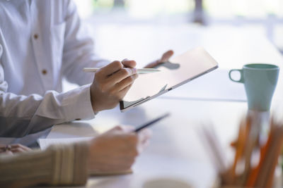 Midsection of woman working on table