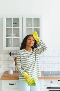 African-american female feeling relief after finishing cleaning kitchen. tired of household duties