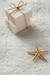 High angle view of soap bars and starfish on white towel