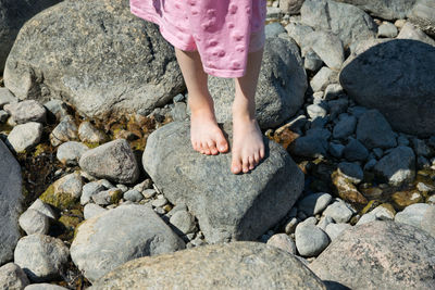 Low section of woman standing on rocks