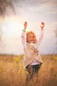 Portrait of girl on field against sky during sunset