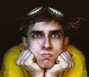 Close-up portrait of young man against black background