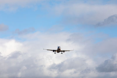 Low angle view of airplane flying against sky