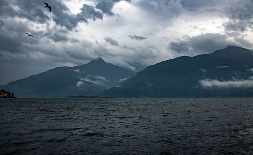 Scenic view of sea and mountains against sky