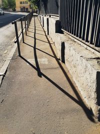 Shadow of railing on footpath in city