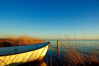 Boat on sea against clear blue sky