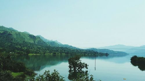 Scenic view of lake and mountains against clear sky