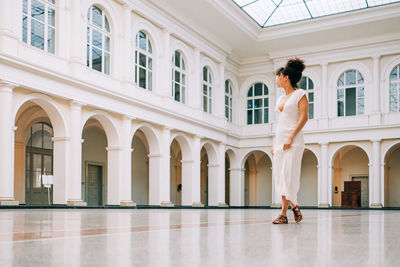 Side view of woman standing against building