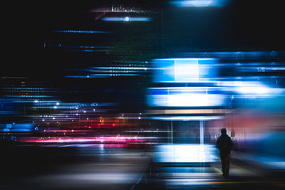 Blurred motion of people walking on road at night