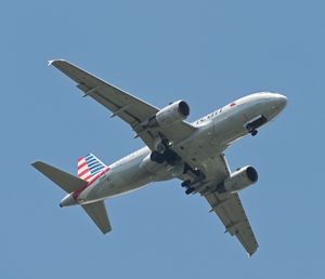 Low angle view of airplane against clear blue sky