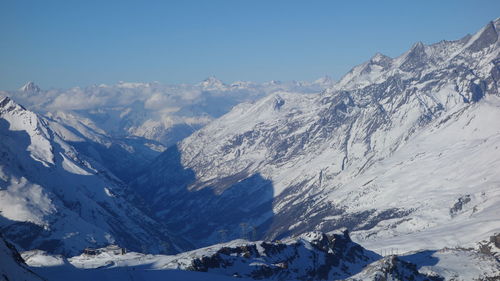 Scenic view of snowcapped mountains against clear blue sky