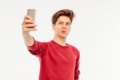 Full length of young man using phone against white background