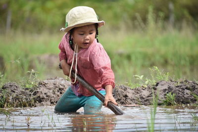 Girl with shovel at rice paddy