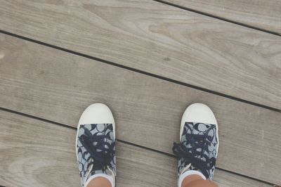 Low section of person standing on hardwood floor