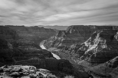 Rock formations on landscape against cloudy sky