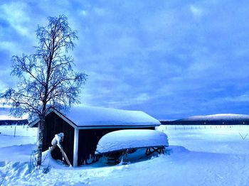 Reflection of woman on snow covered car against sky