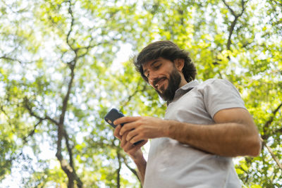 Young man at park on a beautiful sunny day with mobile phone.  working  leisure. green and nature 