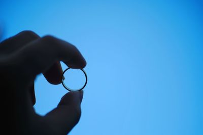 Person holding umbrella against blue sky