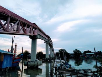 Bridge over river against cloudy sky