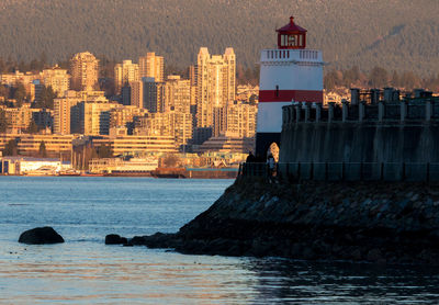 Lighthouse by sea in city