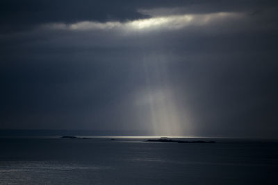 Sunlight streaming through sea against sky