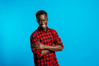 Portrait of a young man against blue background