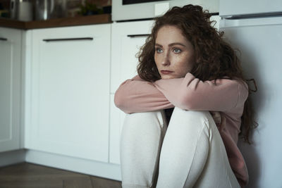 Portrait of young woman standing at home