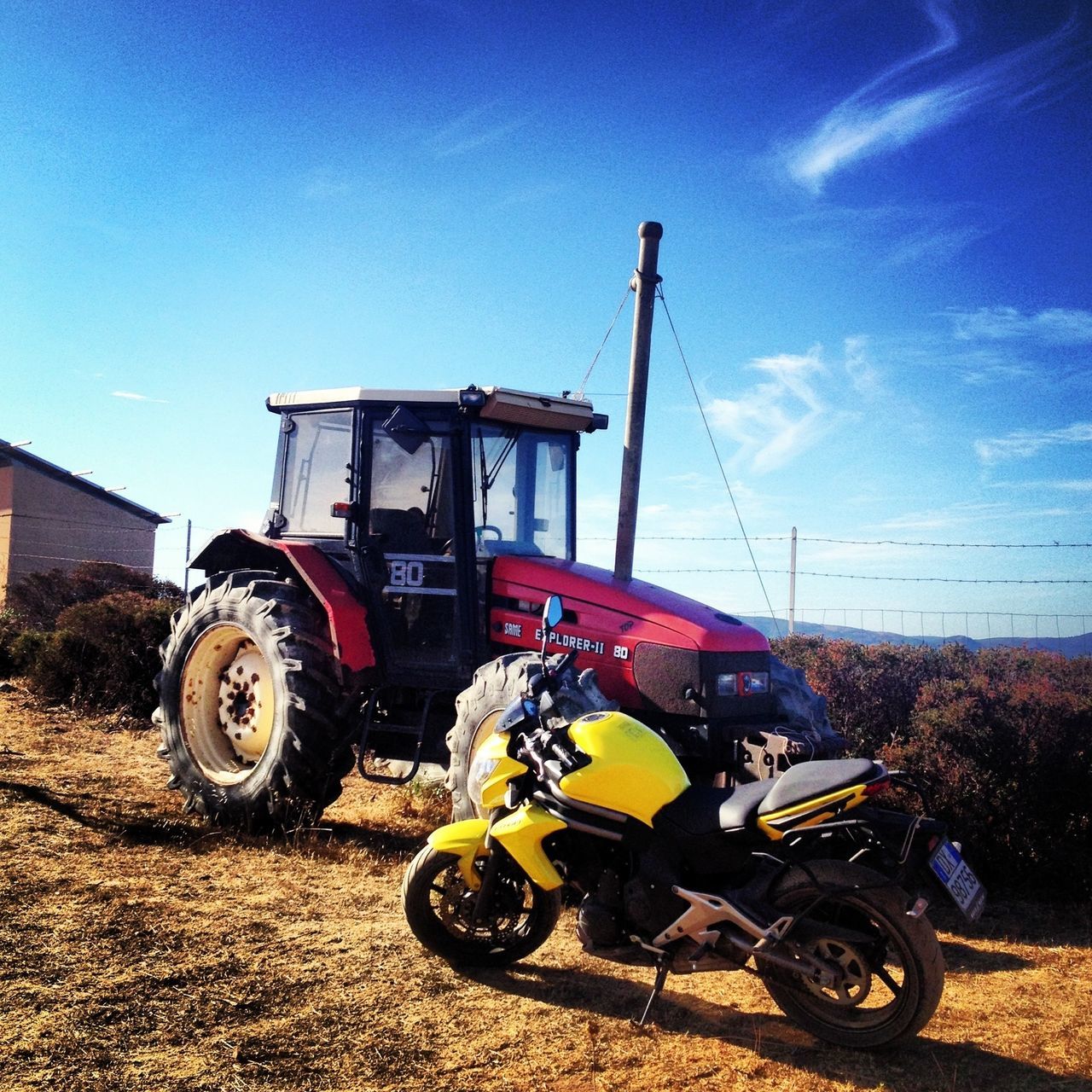 transportation, land vehicle, mode of transport, bicycle, stationary, parked, parking, sky, tractor, blue, motorcycle, car, sunlight, wheel, clear sky, field, travel, day, outdoors, architecture