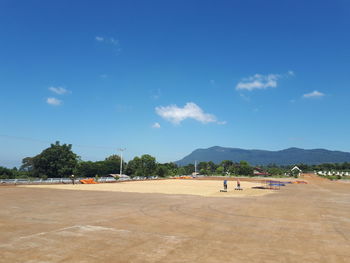 People on beach against blue sky
