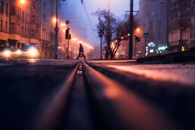 Surface level of railroad track on road in city at night