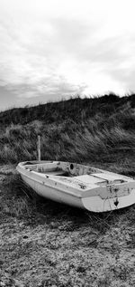 Boat moored on shore against sky