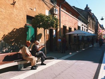 People on alley by buildings in city