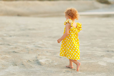 Full length of cute girl standing on beach