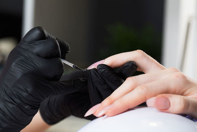 Manicure process in a beauty salon. the manicurist paints the nail with varnish.