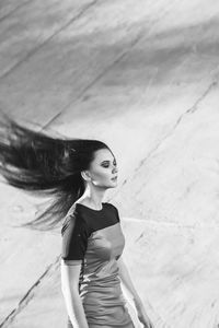 Young woman with tousled hair while standing against wall