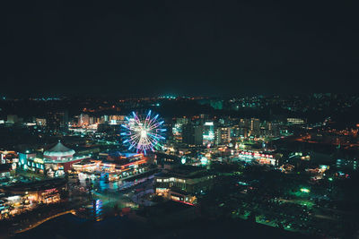 Illuminated city against sky at night