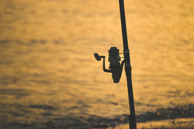 Close-up of silhouette fishing rod on pole