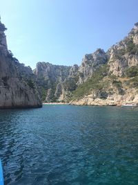 Scenic view of sea and mountains against clear blue sky