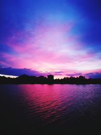 Scenic view of river against sky at sunset