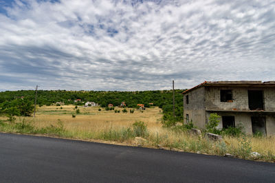 Scenic view of road by buildings against sky